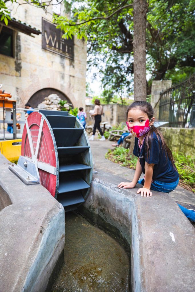 young girl playing with water exhibit