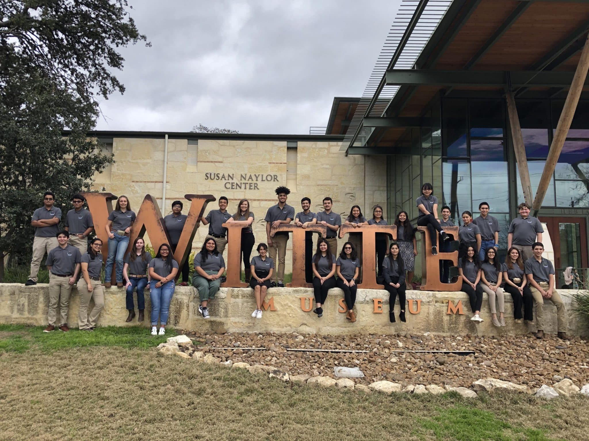 Group photo of teenage volunteers at the Witte sign