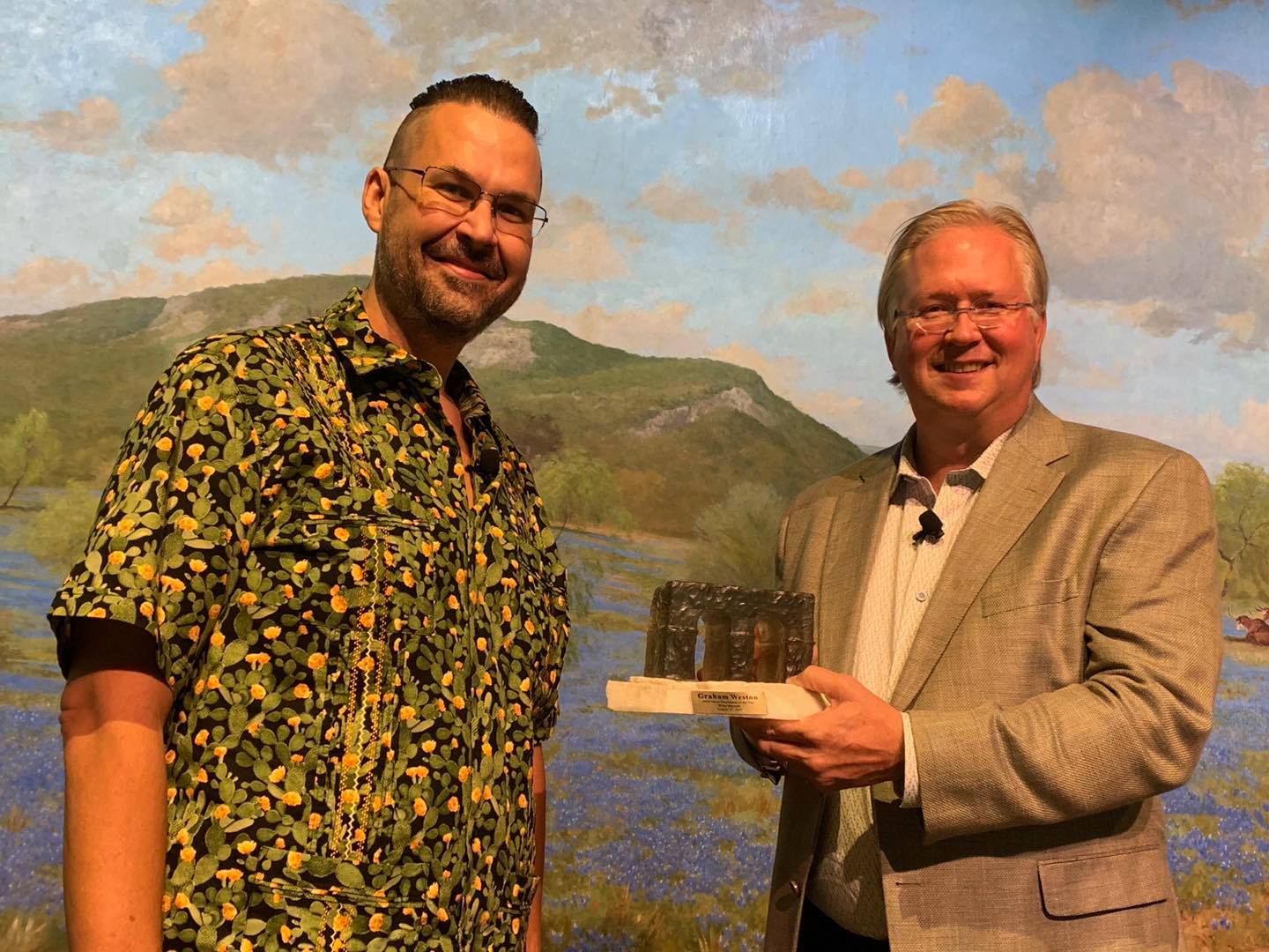 Two men standing in front of artwork