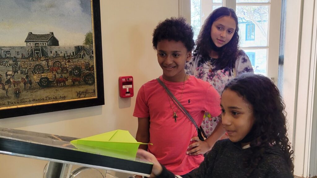 Three children with paper airplane