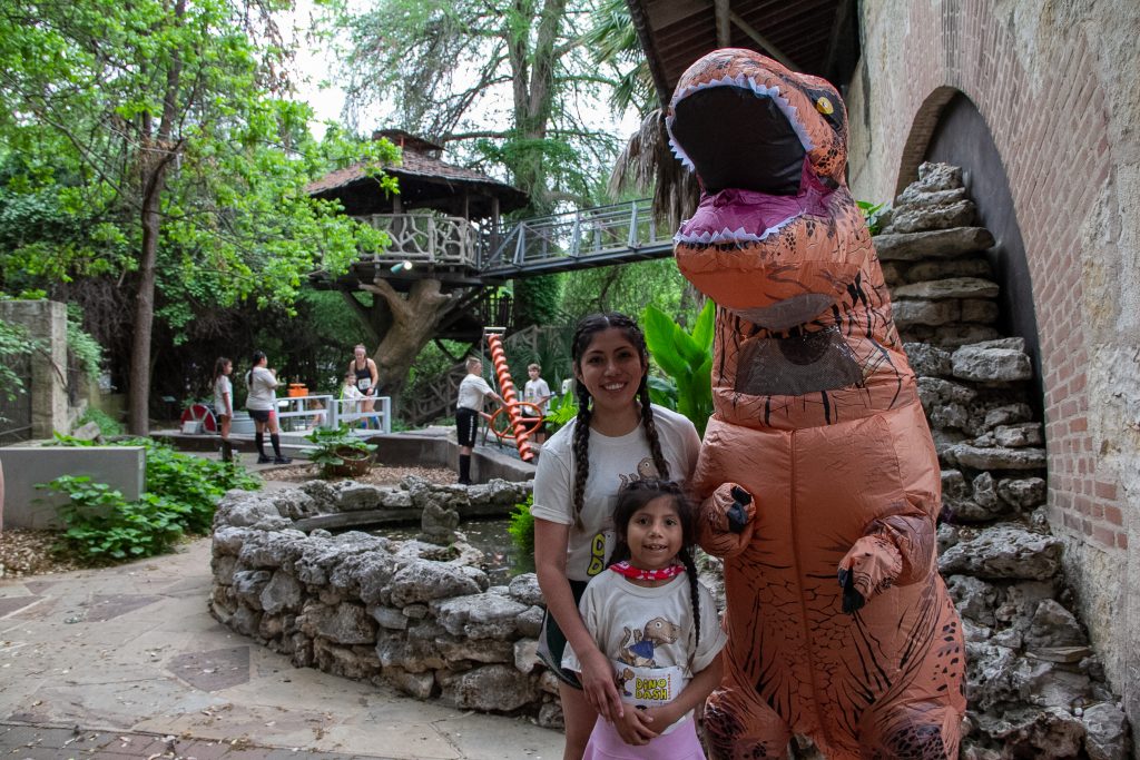 mother and daughter by the dinosaur mascot