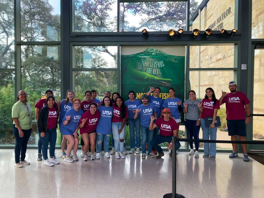 Students wearing UTSA volunteer t-shirts, standing in the HEB Lantern.