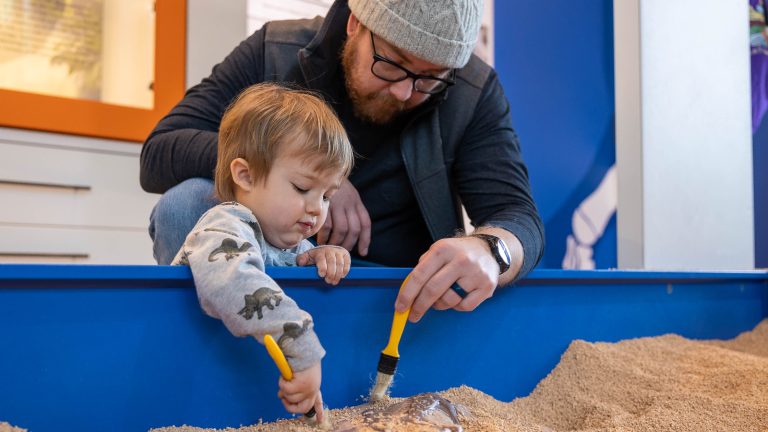 Father and son using the dino dig.