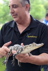 Man holding a small alligator.
