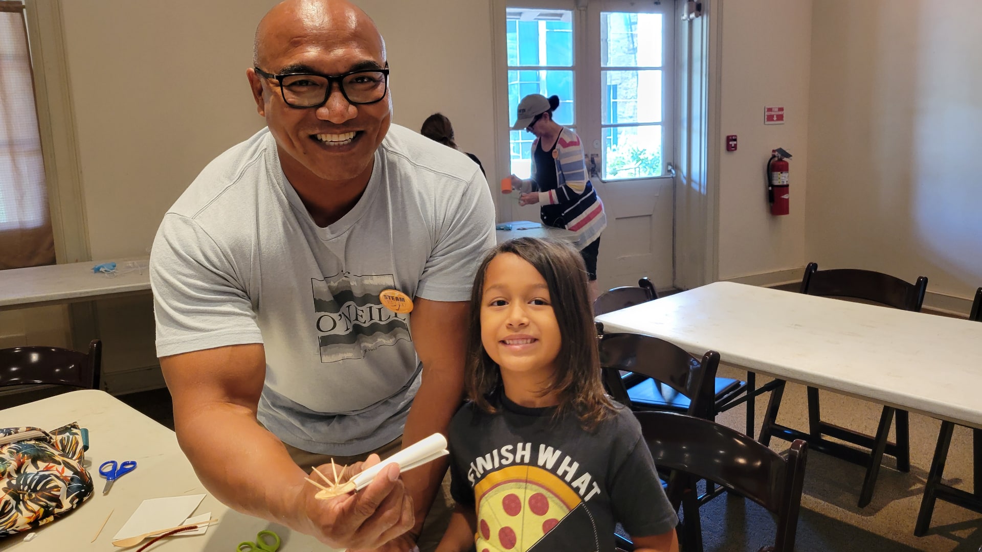 Father and son smile while working on science project.