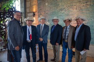6 men wearing jeans, suit jacket and cowboy hats.