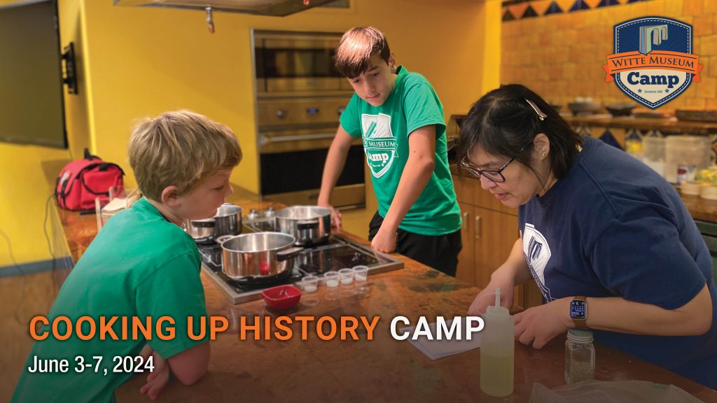 campers and instructor read recipe at kitchen counter.