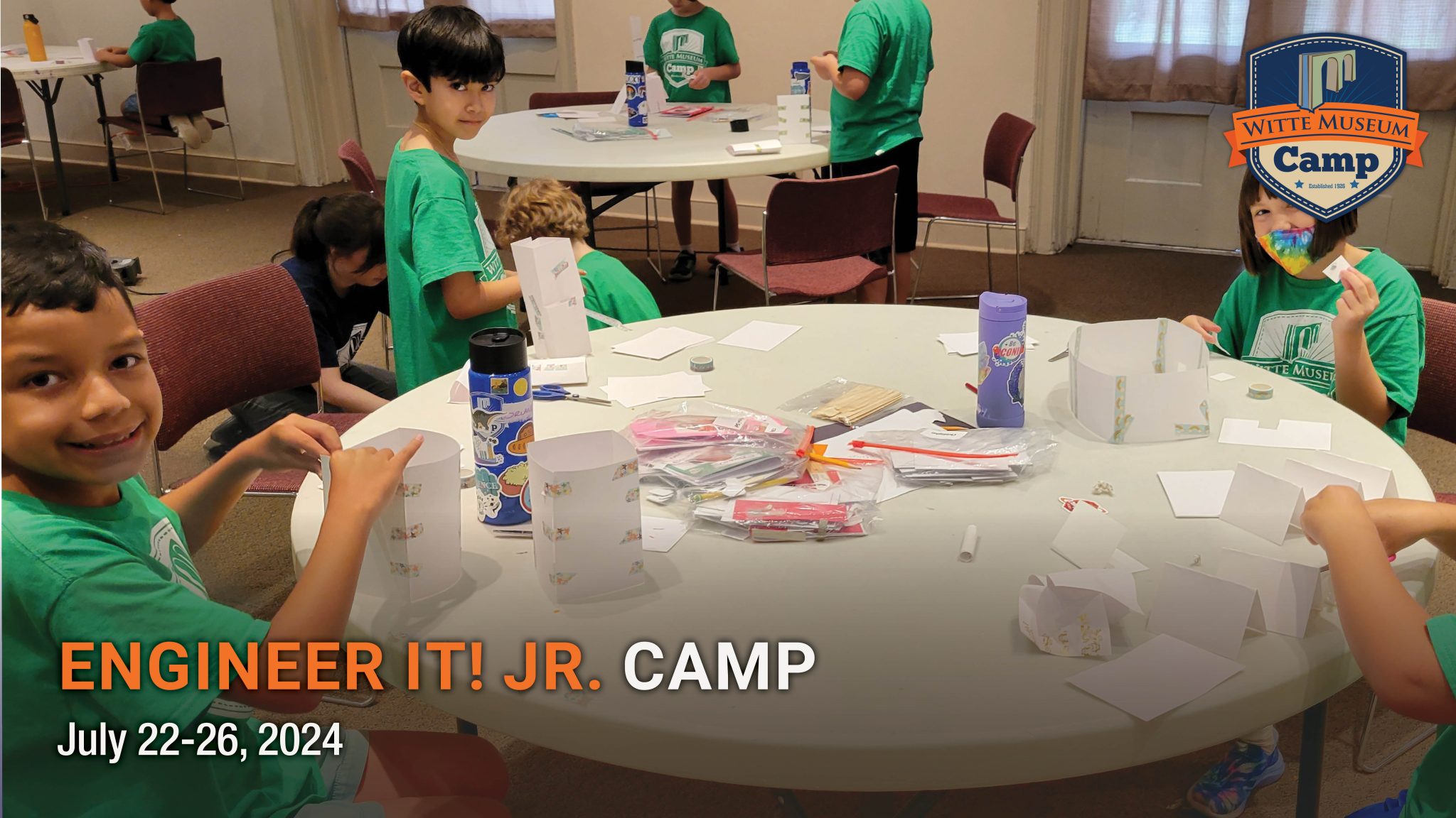 children sit around table building science projects.