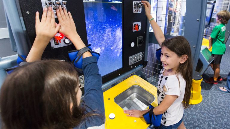 two girls use astronaut training interactive