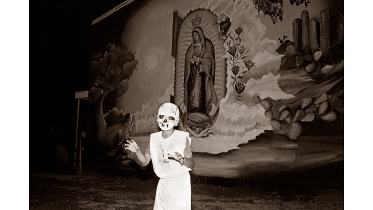 child wears Halloween costume in front of virgin de guadalupe