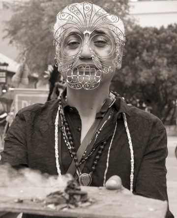 man holds tray while wearing a mask.