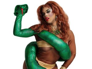 Drag performer wearing brown outfit with green snake around the arm.