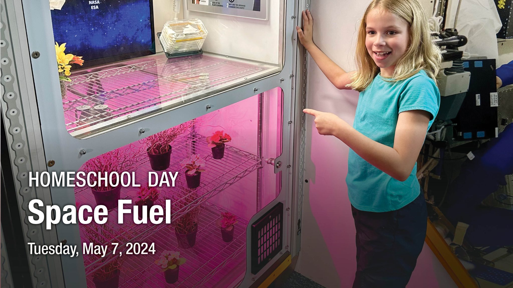 girl points to plants growing in space capsule.