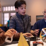 young boy builds shapes with different materials.