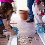 young girl makes air-powered boat
